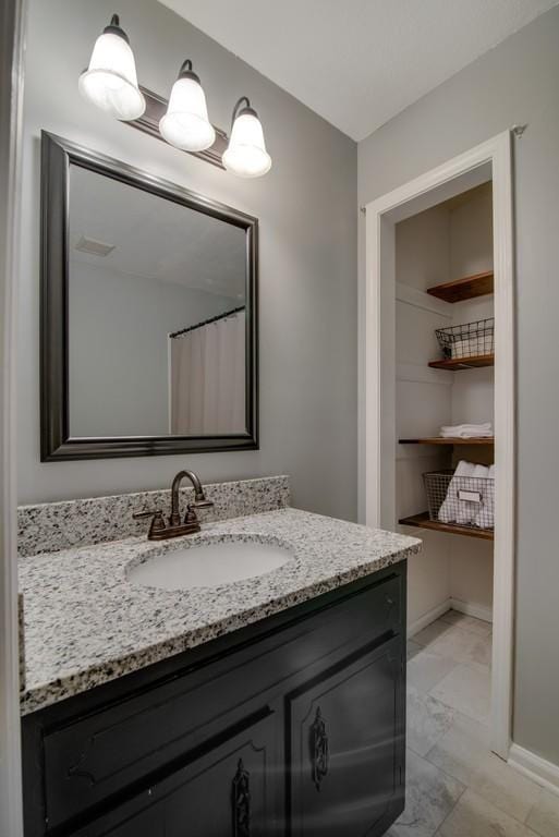 bathroom featuring a shower with shower curtain and vanity