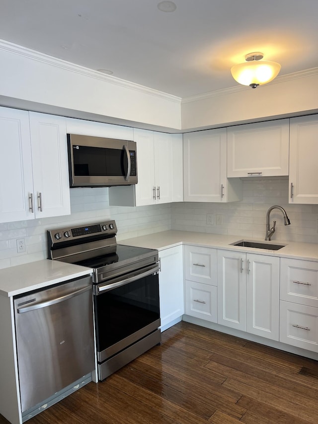 kitchen with white cabinetry, sink, stainless steel appliances, dark hardwood / wood-style floors, and backsplash