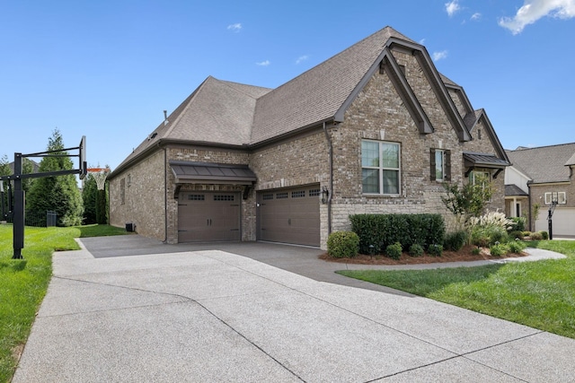 view of side of property featuring a lawn and a garage