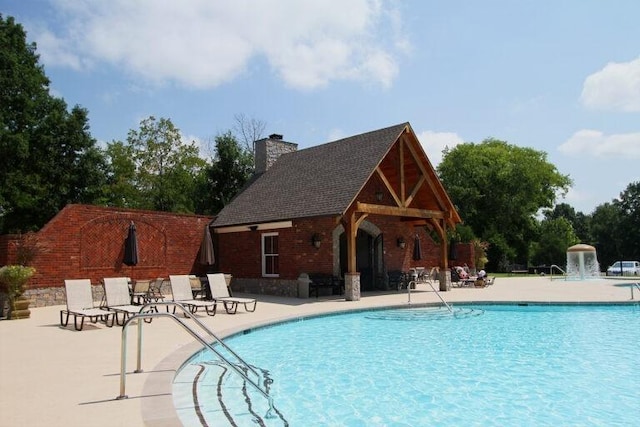 view of pool with pool water feature and a patio