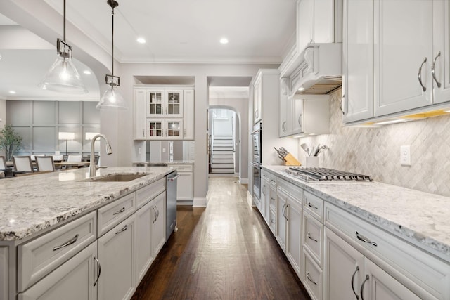 kitchen with light stone counters, custom range hood, dark wood-type flooring, sink, and white cabinets