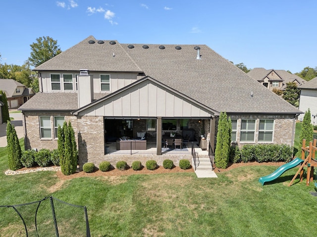 rear view of house with a playground, a patio area, and a yard