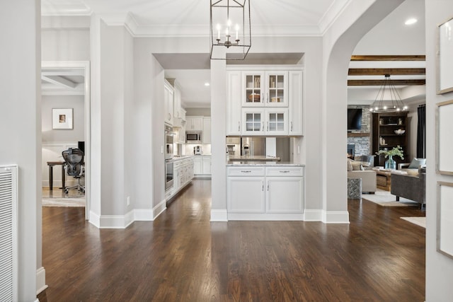 foyer featuring beamed ceiling, ornamental molding, a fireplace, and dark wood-type flooring