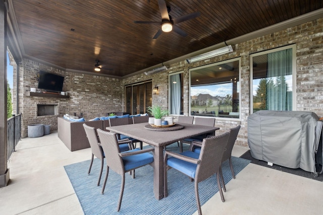 view of patio / terrace featuring area for grilling, an outdoor brick fireplace, and ceiling fan