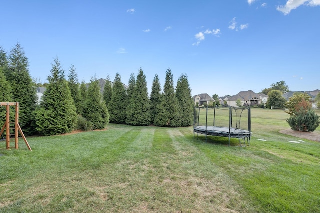 view of yard featuring a playground and a trampoline