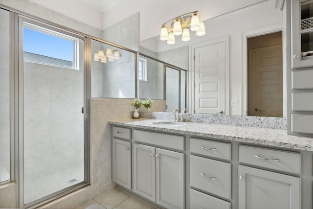 bathroom featuring tile patterned flooring, vanity, walk in shower, and tile walls