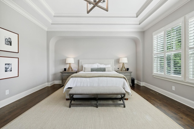 bedroom featuring a raised ceiling, crown molding, and dark hardwood / wood-style flooring