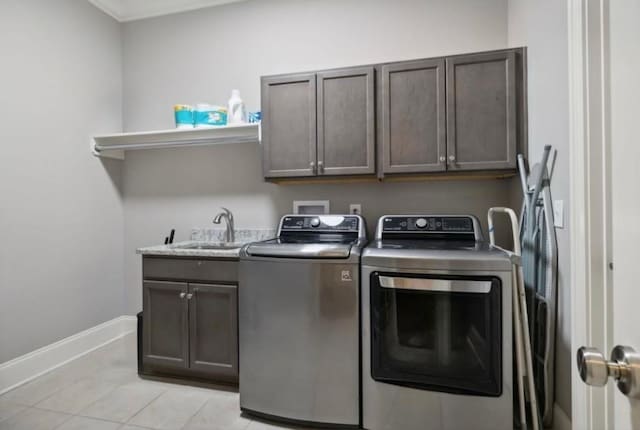 washroom featuring cabinets, independent washer and dryer, sink, and light tile patterned floors