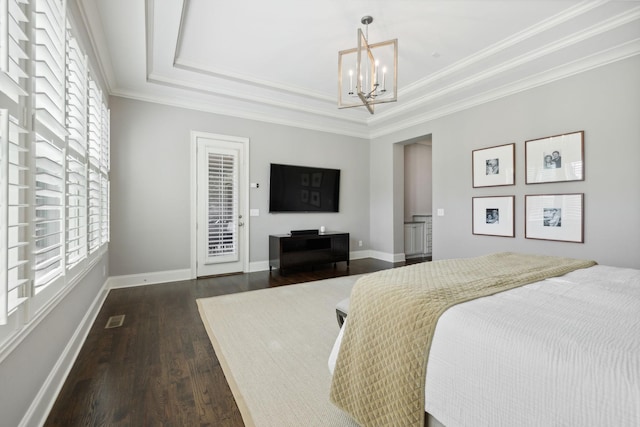 bedroom featuring hardwood / wood-style flooring, a chandelier, multiple windows, and a tray ceiling