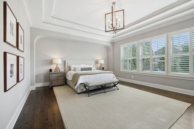 bedroom with a raised ceiling, crown molding, dark hardwood / wood-style flooring, and a notable chandelier