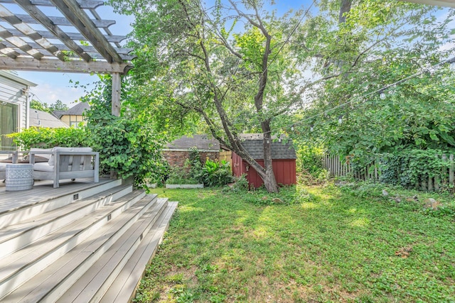 view of yard featuring a shed, a pergola, and a wooden deck