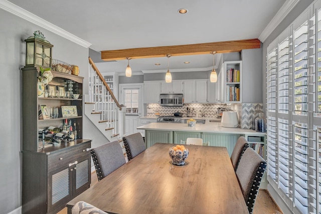 dining room with light wood-type flooring and crown molding