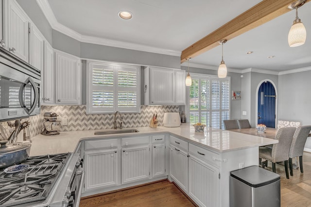 kitchen featuring kitchen peninsula, sink, and white cabinets