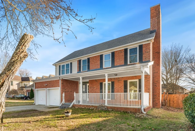 view of front of house featuring covered porch, a garage, and a front lawn