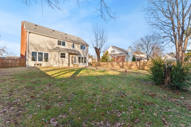 back of house featuring a lawn