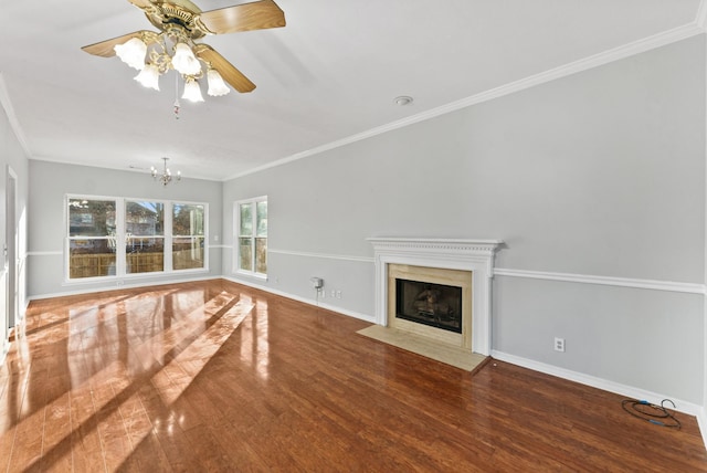 unfurnished living room with a premium fireplace, crown molding, ceiling fan with notable chandelier, and hardwood / wood-style flooring