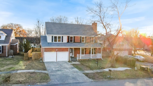 view of front of house featuring a garage, covered porch, and a front yard