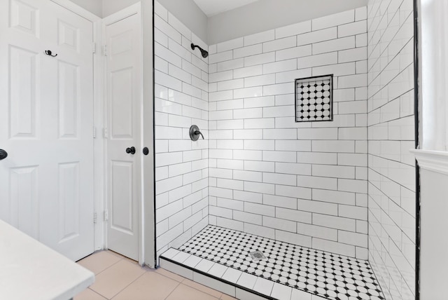 bathroom featuring a tile shower and tile patterned flooring