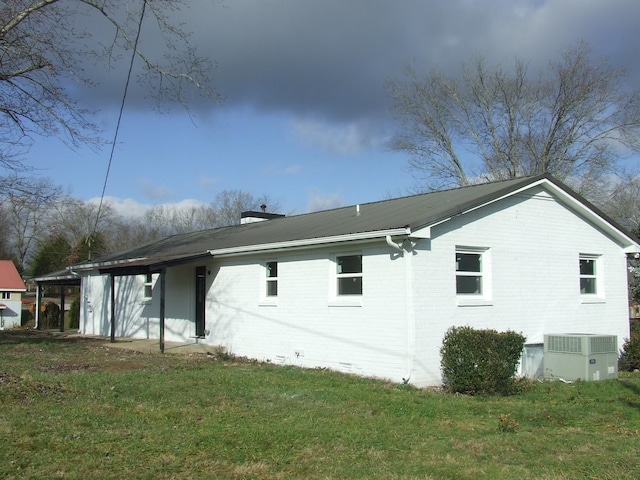 back of property featuring central AC and a yard