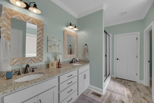 bathroom with vanity, a shower with door, wood-type flooring, and crown molding