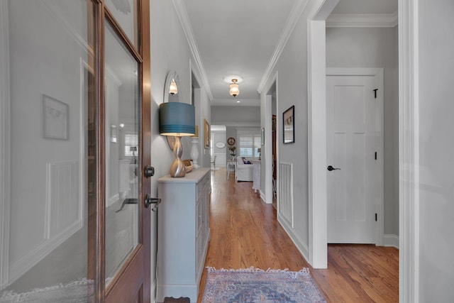 hall featuring light hardwood / wood-style flooring and ornamental molding