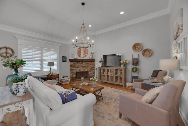 living room with a fireplace, light hardwood / wood-style floors, an inviting chandelier, and ornamental molding