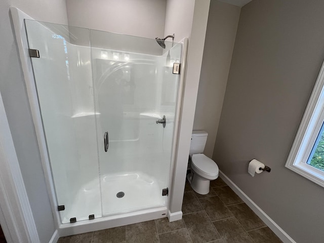 bathroom with a shower with door and toilet