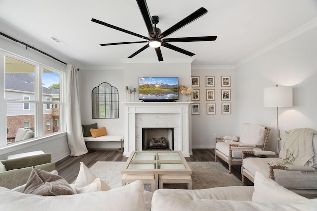 living room with ornamental molding, ceiling fan, and dark wood-type flooring