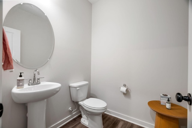 bathroom featuring sink, wood-type flooring, and toilet