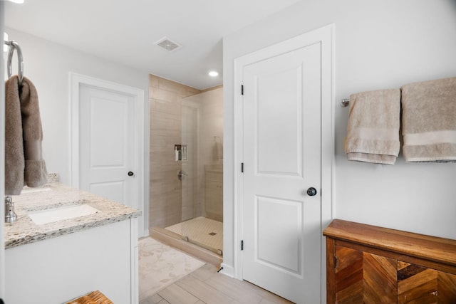 bathroom with vanity and a shower with shower door