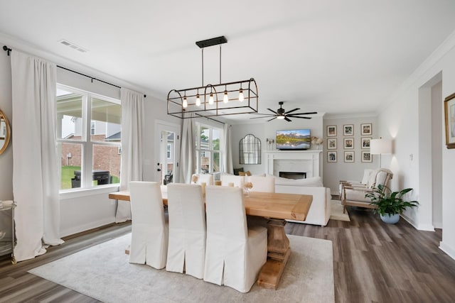 dining space with ceiling fan with notable chandelier, dark hardwood / wood-style floors, and ornamental molding