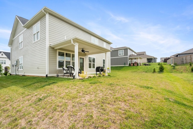 back of property featuring a lawn, ceiling fan, and a patio