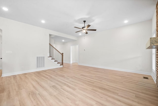 unfurnished living room featuring ceiling fan, light hardwood / wood-style floors, and a fireplace