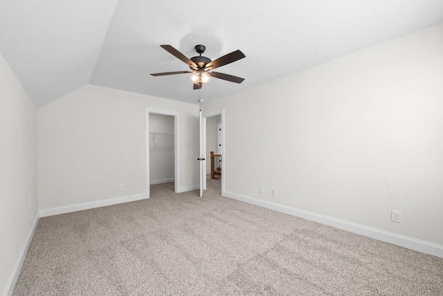 unfurnished bedroom with carpet flooring, ceiling fan, a closet, and lofted ceiling