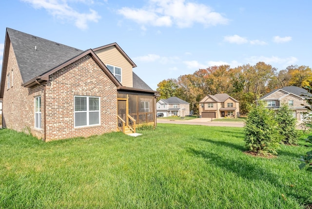 back of property with a yard and a sunroom