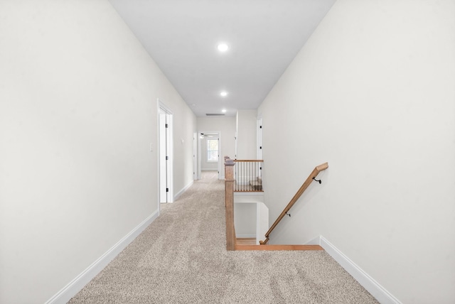 hallway featuring light colored carpet