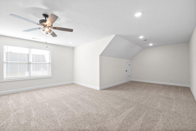 additional living space featuring ceiling fan, light carpet, and vaulted ceiling