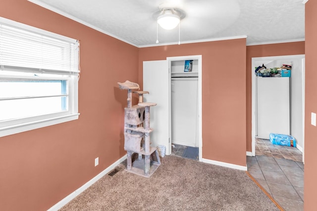 carpeted bedroom with ceiling fan, a closet, crown molding, and a textured ceiling