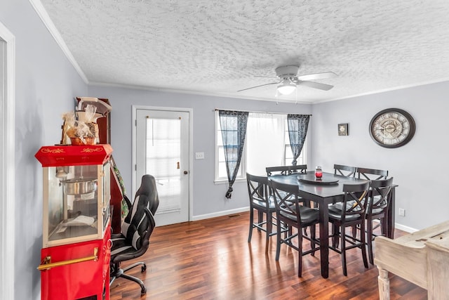 dining room featuring ceiling fan, dark hardwood / wood-style floors, ornamental molding, and a textured ceiling