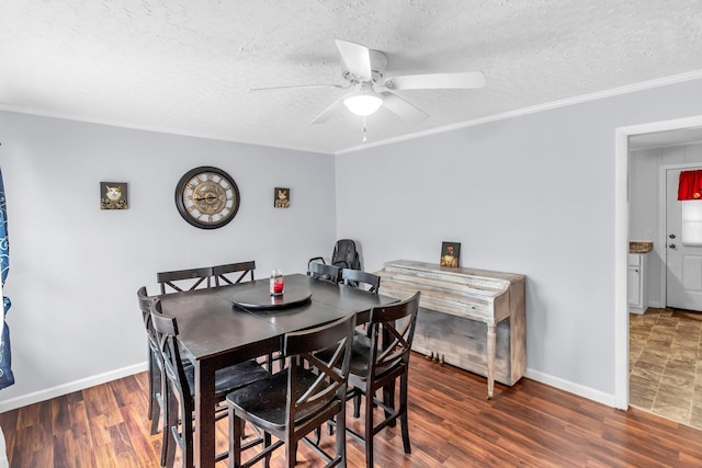 dining room with a textured ceiling, ceiling fan, crown molding, and dark wood-type flooring