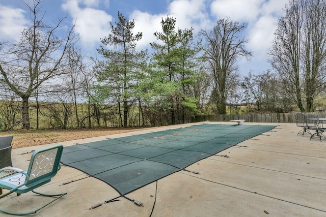 view of swimming pool featuring a diving board and a patio area