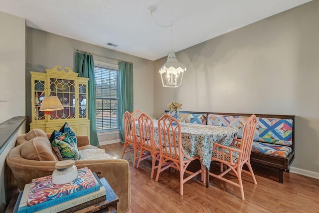 dining area featuring hardwood / wood-style flooring and a chandelier