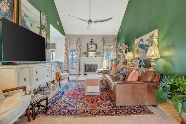 carpeted living room with ceiling fan and high vaulted ceiling