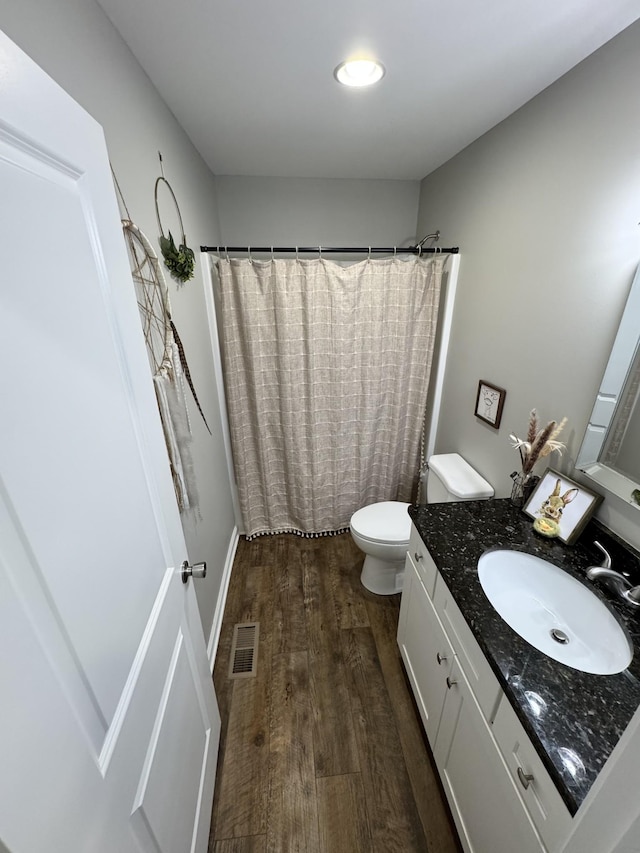 bathroom with hardwood / wood-style flooring, vanity, toilet, and a shower with shower curtain