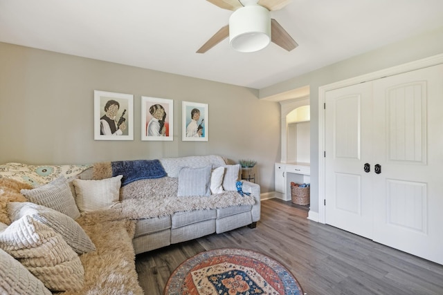 living room featuring ceiling fan and dark wood-type flooring