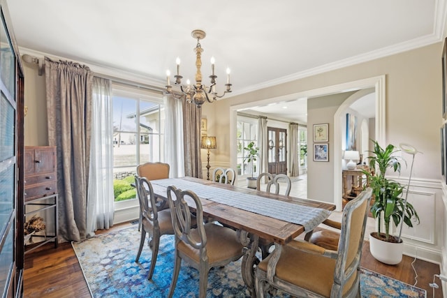 dining area featuring a chandelier, a healthy amount of sunlight, ornamental molding, and dark wood-type flooring