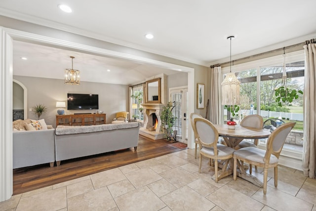 tiled dining area with an inviting chandelier and crown molding