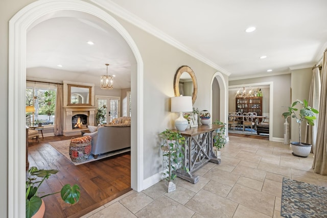 corridor with crown molding and a chandelier