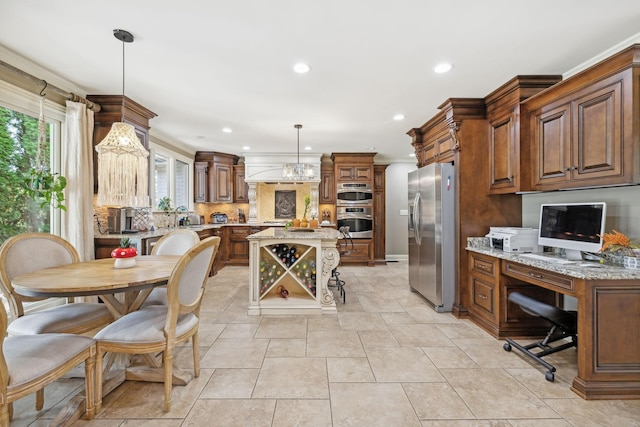 kitchen with appliances with stainless steel finishes, tasteful backsplash, light stone counters, decorative light fixtures, and a kitchen island