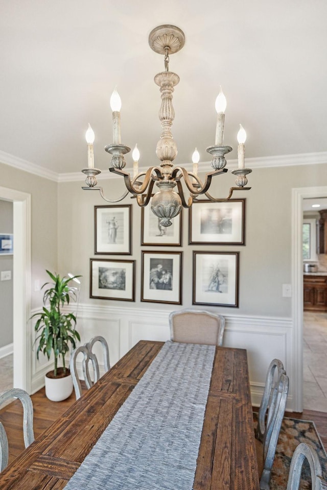 dining room featuring crown molding, wood-type flooring, and a notable chandelier